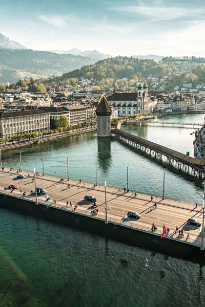 Panorama von Luzern mit Altstadt, Seeufer, und dem Pilatus im Hintergrund bei klarem Wetter.